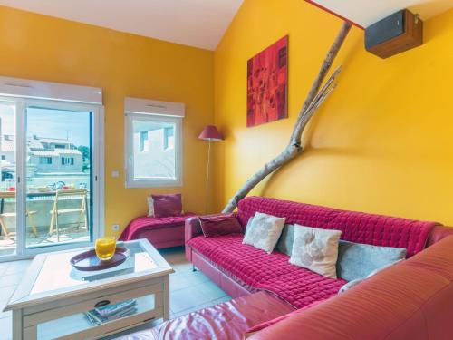 sala de estar con sofá rojo y paredes amarillas en Apartment Antinéa by Interhome, en Les Lecques