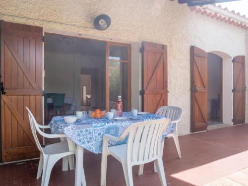 stół z białymi krzesłami i niebieską tkaniną w obiekcie Holiday Home Provence Parc-7 by Interhome w mieście Saint-Cyr-sur-Mer