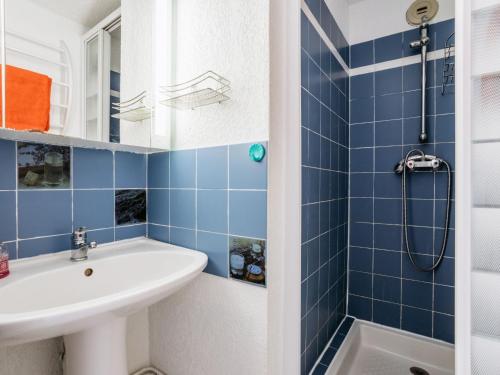 ein blau gefliestes Bad mit einem Waschbecken und einer Dusche in der Unterkunft Apartment Les Roches Bleues-7 by Interhome in Collioure