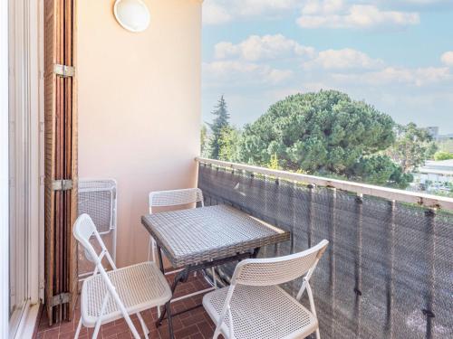 patio con mesa y sillas en el balcón en Apartment Le Cormoran by Interhome, en Le Lavandou