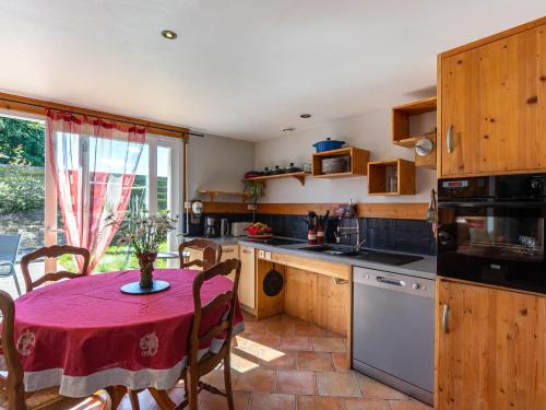 eine Küche mit einem Tisch und einem roten Tischtuch in der Unterkunft Holiday Home La Longère by Interhome 