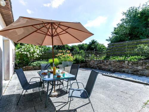 einen Tisch und Stühle mit Sonnenschirm auf einer Terrasse in der Unterkunft Holiday Home La Longère by Interhome 