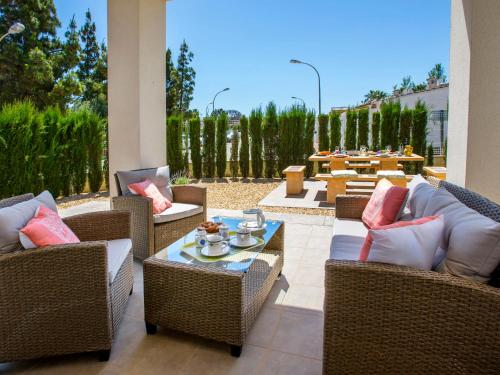 une terrasse avec des chaises en osier, une table et un astérisque de table dans l'établissement Holiday Home Jill by Interhome, à Els Poblets