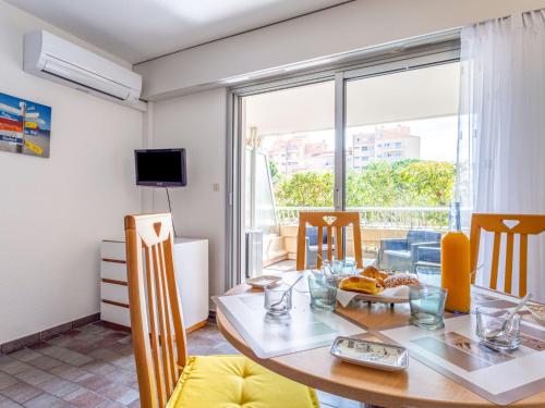 une salle à manger avec une table et des chaises et une fenêtre dans l'établissement Studio Port de La Gavine-27 by Interhome, à Hyères