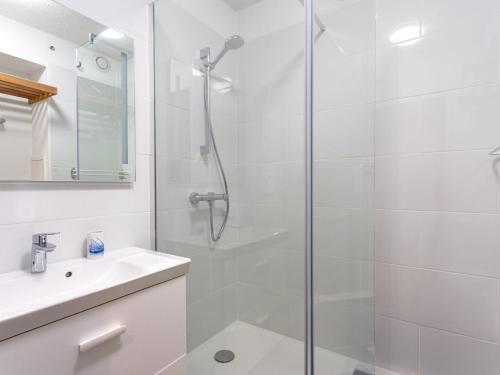 une salle de bain blanche avec une douche et un lavabo dans l'établissement Studio Port de La Gavine-27 by Interhome, à Hyères