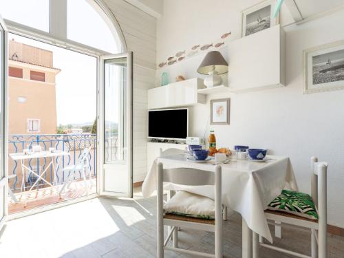 une salle à manger blanche avec une table et un balcon dans l'établissement Apartment Place Spoerry by Interhome, à Grimaud