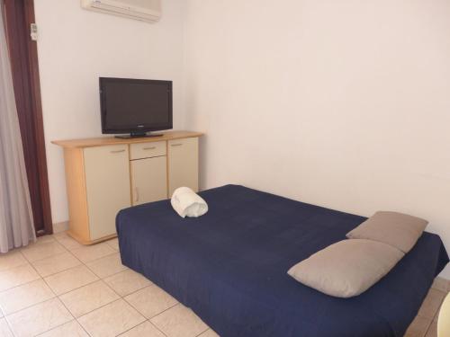 - une chambre avec un lit et une télévision sur une table dans l'établissement Apartment Les Caroubiers-2 by Interhome, à Saint-Aygulf