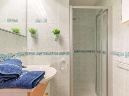 La salle de bains est pourvue d'une douche et d'un lavabo blanc. dans l'établissement Apartment Les Caroubiers-2 by Interhome, à Saint-Aygulf