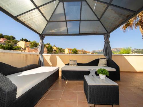 eine Terrasse mit Sofas und Tischen auf dem Dach in der Unterkunft Holiday Home Lilia Rosas by Interhome in Calpe