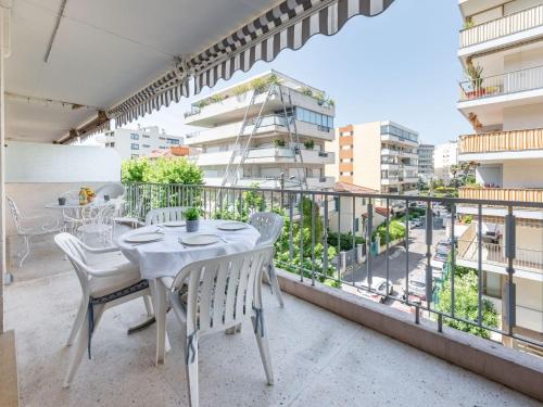 une table et des chaises sur un balcon avec vue sur une ville dans l'établissement Apartment Le Valencia by Interhome, à Cannes