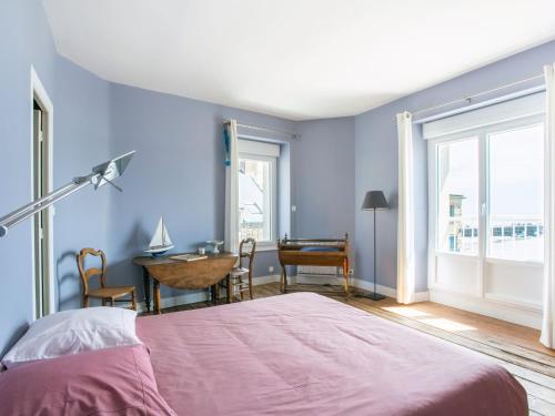 - une chambre avec des murs bleus et un lit avec une table dans l'établissement Apartment La Vigie by Interhome, à Cancale
