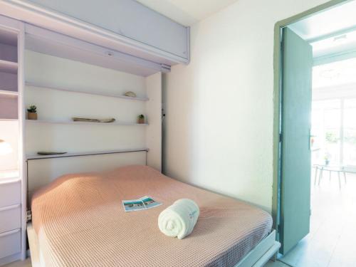 une chambre avec un lit avec un oreiller dessus dans l'établissement Apartment Le Front de Mer-4 by Interhome, à Saint-Aygulf