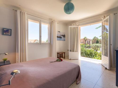 une chambre avec un grand lit et une grande fenêtre dans l'établissement Apartment Le Roumanille by Interhome, à Saint-Aygulf