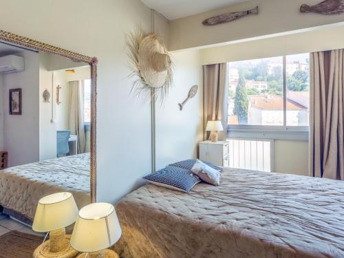 une chambre avec un grand lit avec un grand miroir dans l'établissement Apartment La Méridienne-5 by Interhome, au Lavandou