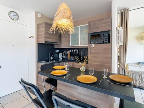 Una cocina con una mesa con platos y vasos encima. en Apartment La Méridienne-5 by Interhome, en Le Lavandou