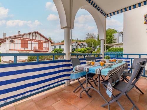 un patio avec une table et des chaises sur un balcon dans l'établissement Apartment Résidence Tingitana-4 by Interhome, à Saint-Jean-de-Luz