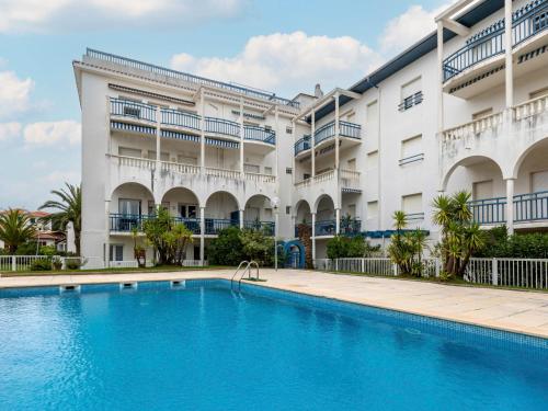 un hôtel avec une piscine devant un immeuble dans l'établissement Apartment Résidence Tingitana-4 by Interhome, à Saint-Jean-de-Luz