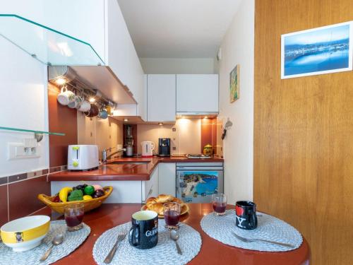 a kitchen with two tables with drinks and a bowl of fruit at Studio Le Grand Foc-3 by Interhome in Cavalaire-sur-Mer