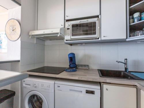 une cuisine avec un lave-linge et un micro-ondes dans l'établissement Apartment Les Bastides - O4 259 by Interhome, à Agay