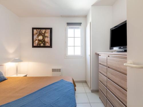 une chambre avec un lit et une télévision à écran plat dans l'établissement Apartment Les Bastides - O4 259 by Interhome, à Agay