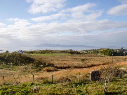 a field of grass with a fence in the foreground at Holiday Home Joan's House by Interhome in Tarskavaig