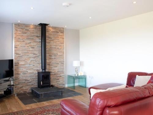 a living room with a brick wall and a fireplace at Holiday Home Joan's House by Interhome in Tarskavaig