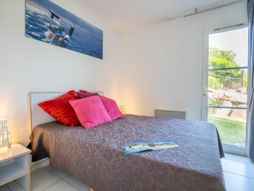 - une chambre dotée d'un lit avec des oreillers rouges et roses dans l'établissement Apartment Les Bastides - O6 014 by Interhome, à Agay