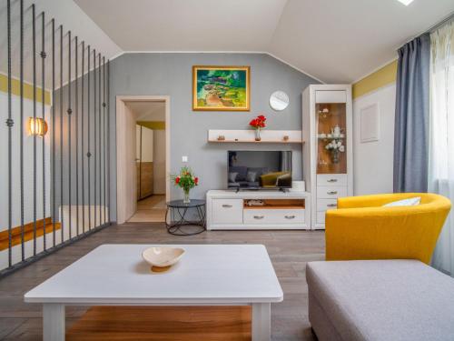 salon ze stołem i żółtym krzesłem w obiekcie Holiday Home Veli by Interhome w mieście Veli Brgud