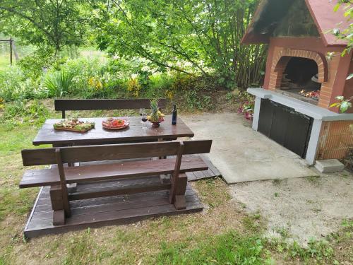 a picnic table with food and a grill in a yard at Holiday House Trnovac in Trnovdc