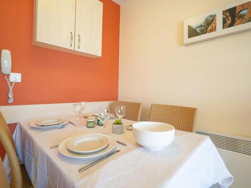 une table avec des assiettes et un bol dessus dans l'établissement Apartment L'Esquinade FH 003 by Interhome, à Agay