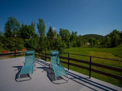 two blue chairs sitting on a patio near a fence at Chalet The Fox by Interhome in Zlobin