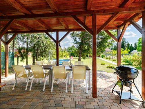 a patio with a table and chairs and a grill at Holiday Home Pear Trees by Interhome in Balatonmáriafürdő