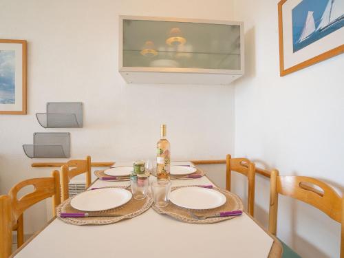 - une table à manger avec des assiettes et une bouteille dans l'établissement Studio Le Belvédère - R3 221 by Interhome, à Agay