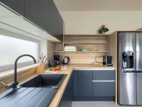 a kitchen with a sink and a stainless steel refrigerator at Holiday Home Villa Lea by Interhome in Šišan