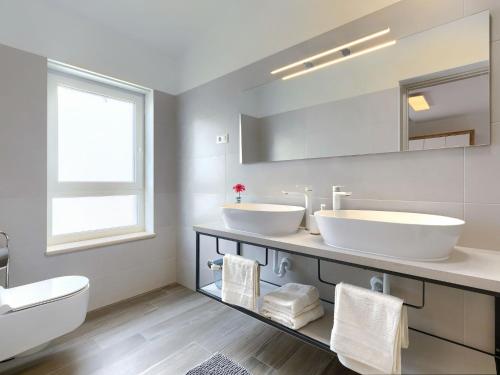 a white bathroom with two sinks and a toilet at Holiday Home Villa Lea by Interhome in Šišan