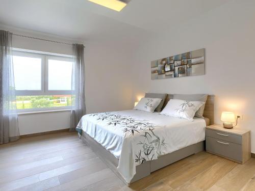 a white bedroom with a bed and a window at Holiday Home Villa Lea by Interhome in Šišan