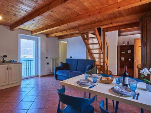 a living room with a table and blue chairs at Apartment Dado by Interhome in Bellano