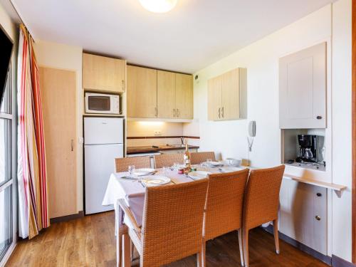 une cuisine avec une table et des chaises dans une pièce dans l'établissement Apartment Village Cap Estérel - L'Esquinade-56 by Interhome, à Agay