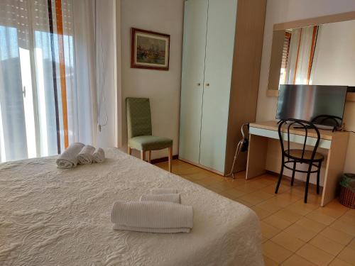 a bedroom with a bed with a desk and a chair at Hotel San Domingo in Lido di Camaiore