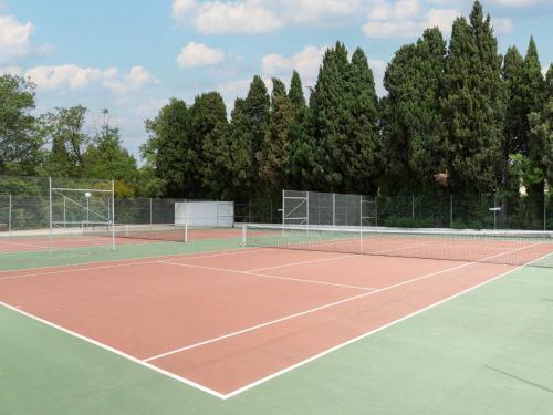 un court de tennis avec des arbres en arrière-plan dans l'établissement Holiday Home Val d'Alpilles by Interhome, à Maussane-les-Alpilles