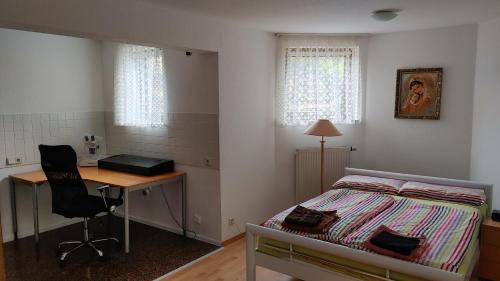 una camera con letto, scrivania e di Gemütliche Einliegerwohnung ohne Küche in Hösbach-Rottenberg a Hösbach