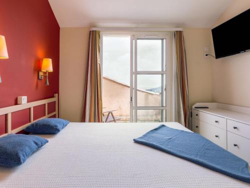 une chambre avec un grand lit et une fenêtre dans l'établissement Apartment L'Esquinade - P3 213 by Interhome, à Agay