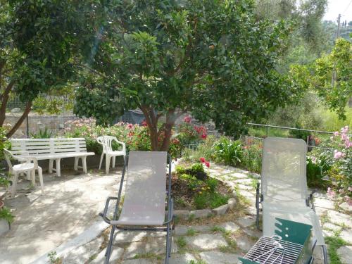 two chairs and a table and a tree in a garden at Holiday Home Ca'Mea by Interhome in Chiusanico