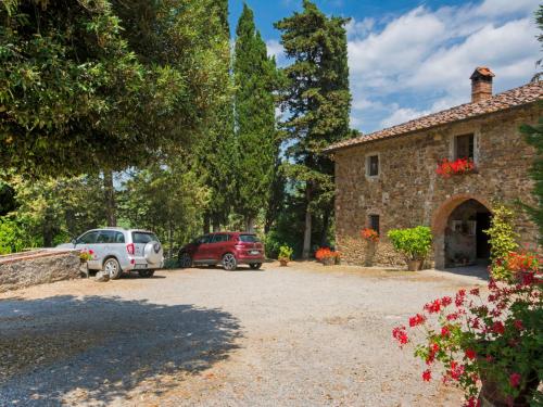 dwa samochody zaparkowane przed kamiennym budynkiem w obiekcie Holiday Home Le Bonatte by Interhome w mieście Radda in Chianti