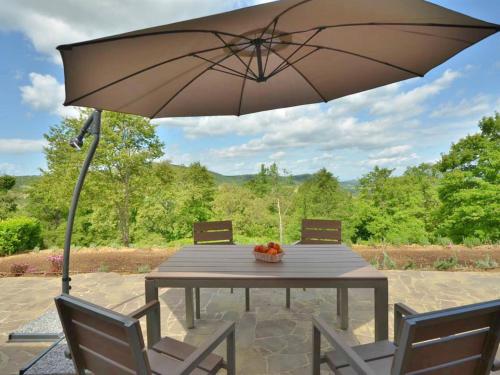 een tafel met een parasol op een patio bij Holiday Home VIlla Basilico by Interhome in Petroio