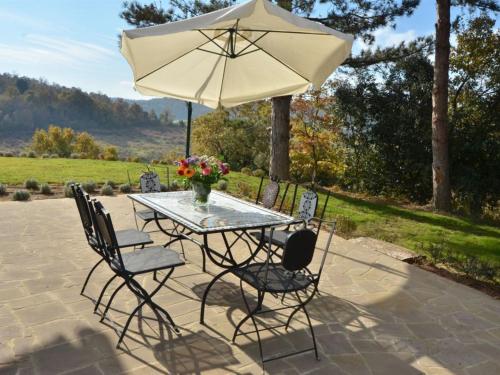 - une table et des chaises avec un parasol sur la terrasse dans l'établissement Holiday Home VIlla Cielo by Interhome, à Osteria Delle Noci