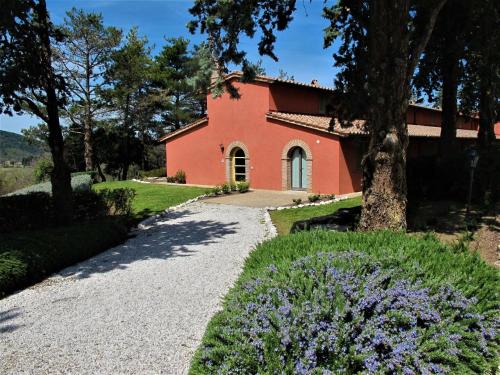 un chemin menant à une maison rouge avec des arbres et des fleurs violettes dans l'établissement Holiday Home VIlla Cielo by Interhome, à Osteria Delle Noci