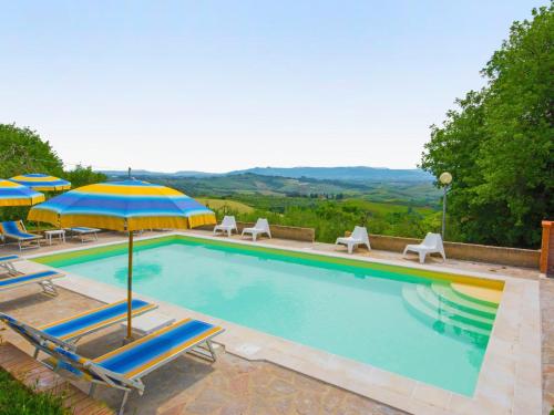 uma piscina com cadeiras e um guarda-sol em Holiday Home La Salamandra by Interhome em Montaione