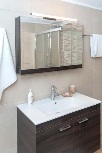 a bathroom with a sink and a mirror at Welcoming apartment with mountain view - 80 m² - Ρούστικα in Roústika