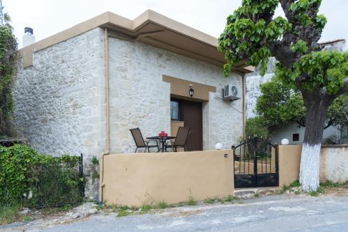 a house with a table and chairs in front of it at Welcoming apartment with mountain view - 80 m² - Ρούστικα in Roústika